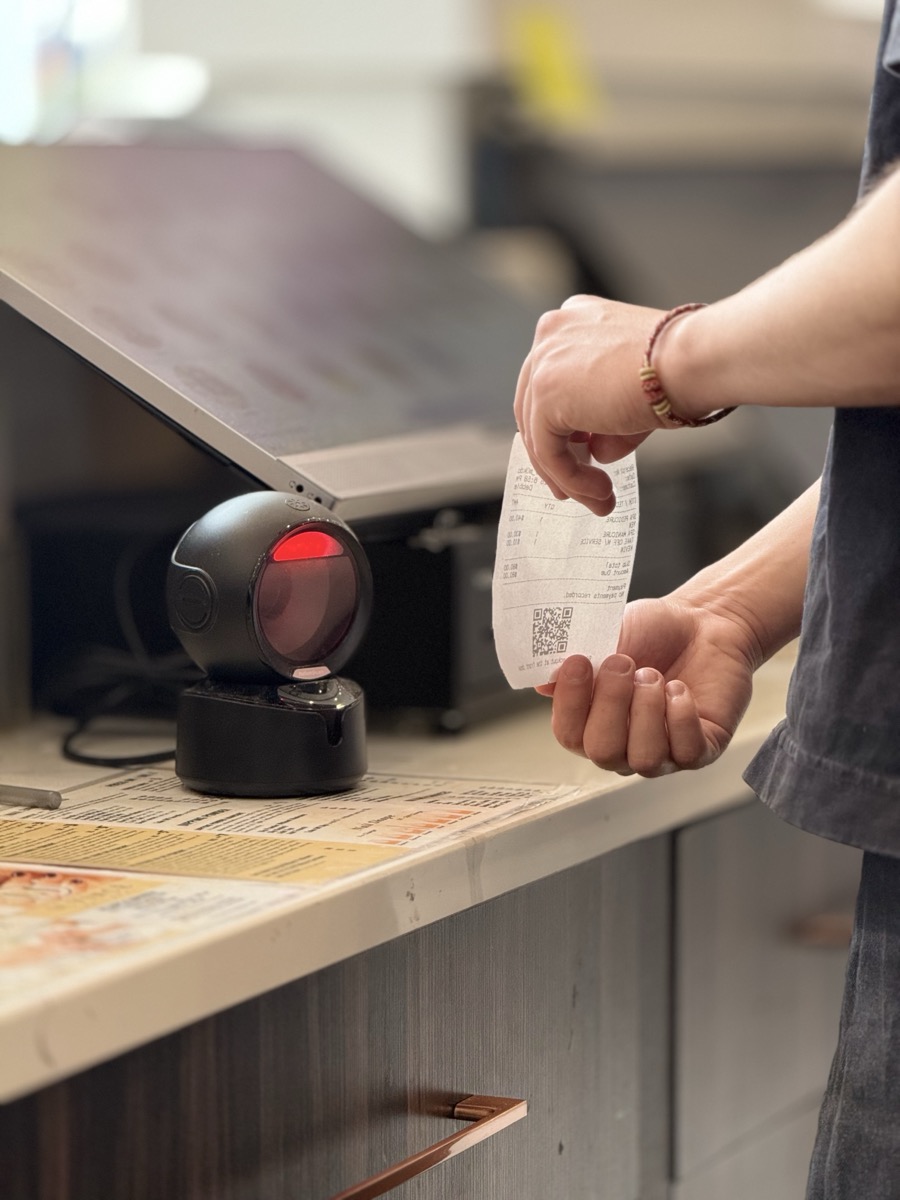 Salon team member scanning a printed checkout ticket